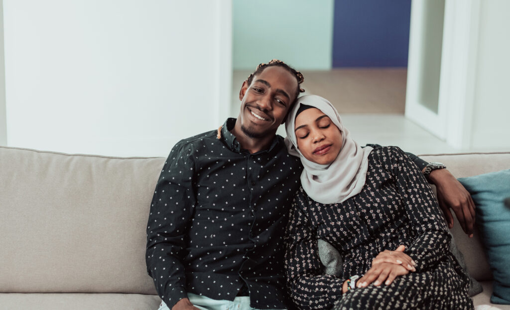 A couple cuddling on a couch.