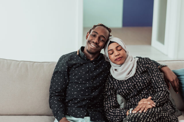 A couple cuddling on a couch.