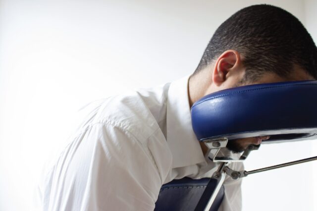 Person laying face down in a massage chair