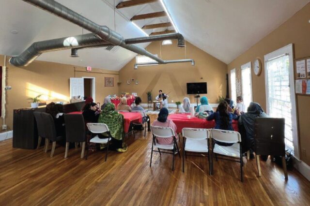 Photo of empty event space, showing chairs and decorated tables and