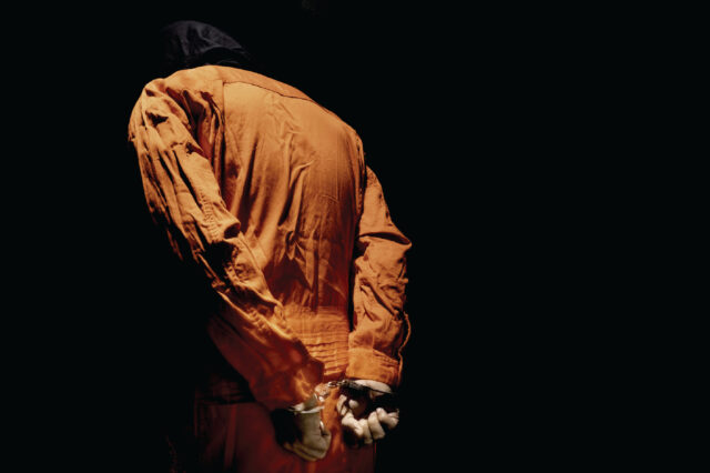 Person in an orange jumpsuit with their back towards the camera.