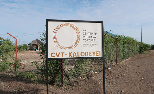 The front sign for CVT Kalobeyei. It reads "The Center for Victims of Torture" "Restoring the Dignity of Human Rights" "CVT Kalobeyei"