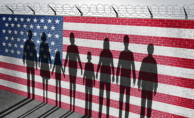 A brick wall with barbed wire, painted with the American flag. Several silhouettes line the wall.